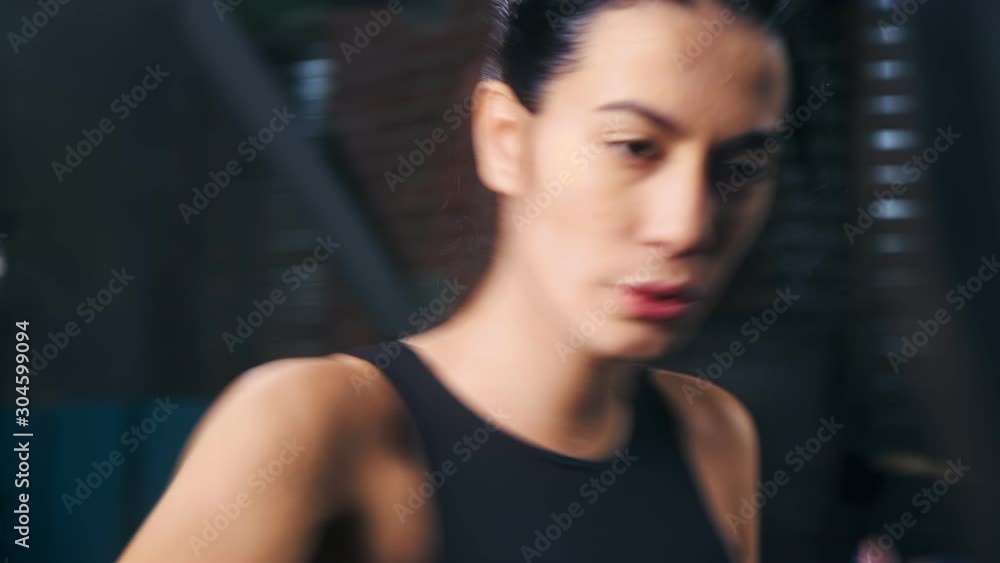 Strong multiethnic young boxer lady with wrapped hand making beating gesture at box studio Strong multiethnic young boxer lady with wrapped hand making beating gesture at box studio