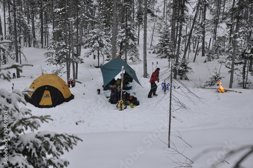 Winter camp in the mountain taiga while snowshoeing.