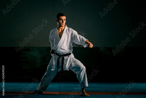 Karate martial arts fighter in white kimono in the gym