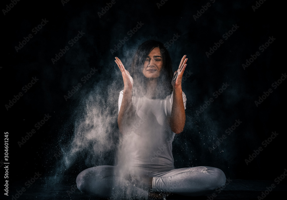 young woman doing yoga poses with flour