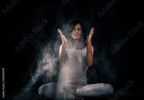 young woman doing yoga poses with flour © Mikko