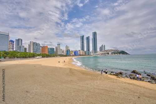 Scenic view of awesome sand beach, sea and skyscrapers in Busan in South Korea. Beautiful summer cloudy look of relax place in resort city in Republic of Korea