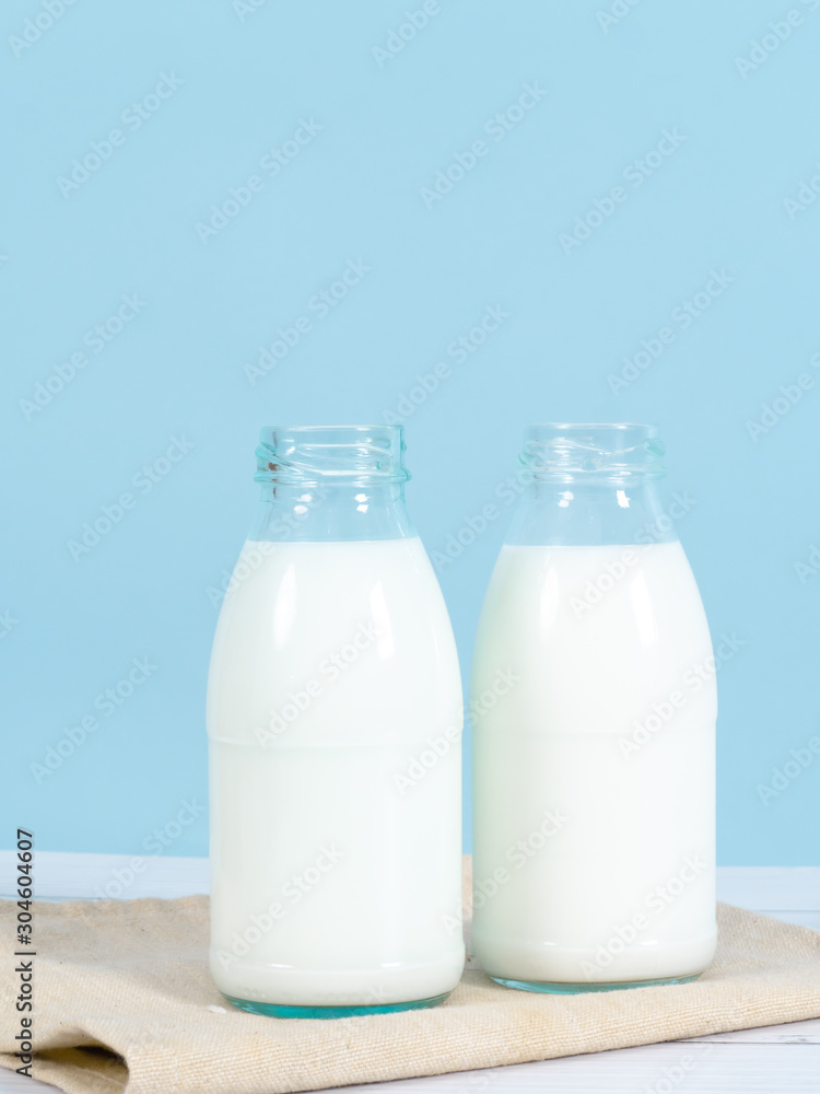 Milk bottle on table with blue background. Milk bottle on table with blue background.