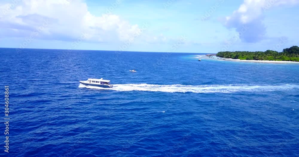 Speed boat sailing across vibrant blue sea surface leaving shore of tropical island toward deep ocean on a bright morning sky with purple clouds in Hawaii Speed boat sailing across vibrant blue sea surface leaving shore of tropical island toward deep ocean on a bright morning sky with purple clouds in Hawaii