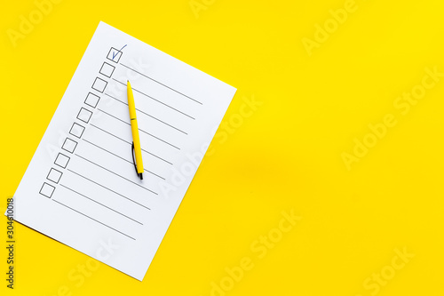 Obraz na plátne Empty check list ready to fill on yellow background top view space for text