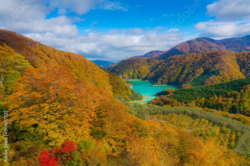 View from Naeba-Tashiro Dragondola, Japans longest ropeway. Autumnal fall leaves with a turquoise blue lake formed by the Futai Dam, Kiyotsu & Asagai Rivers in Naeba, Yuzawa, Niigata Prefecture, Japan
