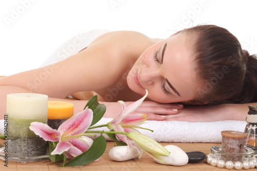 Young woman on massage table with candles