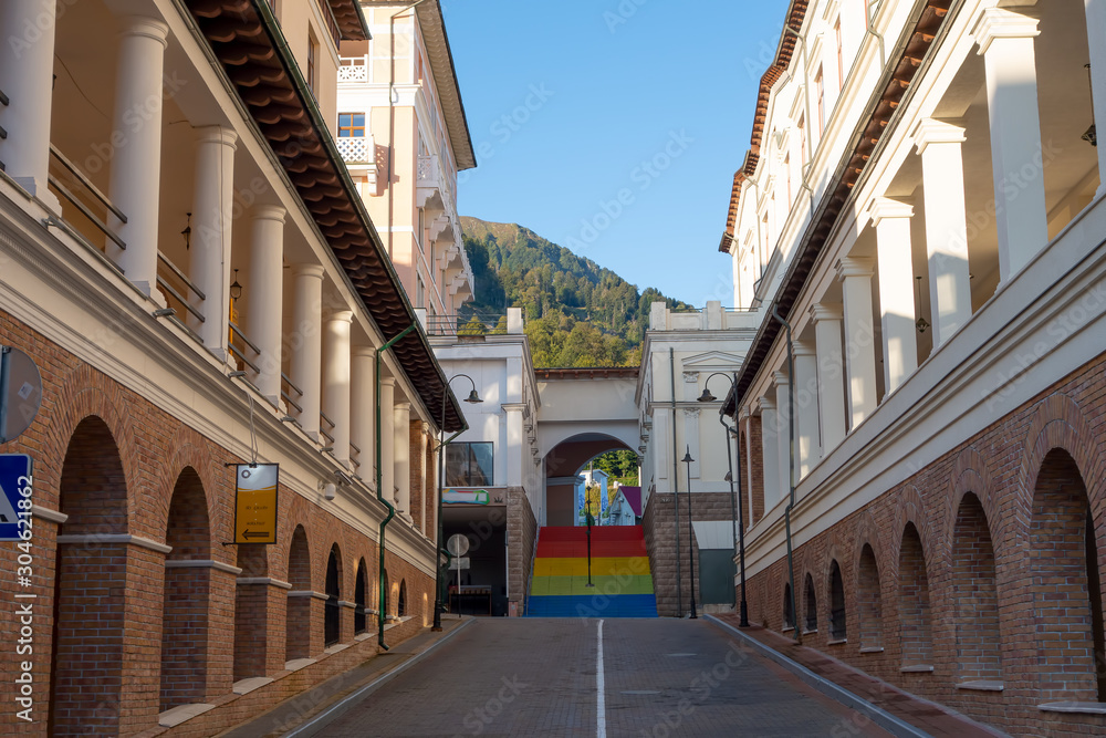 The empty street with a multicolored staircase leading up under the arch. Tourist village in the mountains of the Caucasus