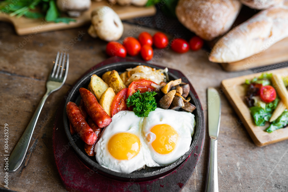 breakfast fried scrambled eggs with sausages and potatoes in a pan on a beautiful background breakfast fried scrambled eggs with sausages and potatoes in a pan on a beautiful background