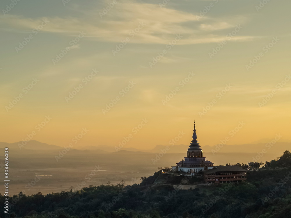 Mountain view evening of Crystal Pagoda or Chedi Kaew on top hill with yellow sun light in the sky background, sunset at Wat Tha Ton, Tha Ton District, Fang, Chiang Mai, northern of Thailand.