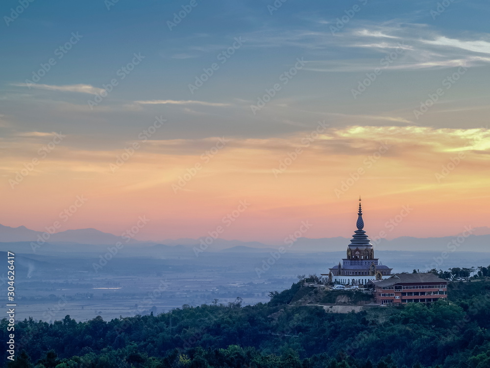Mountain view evening of Crystal Pagoda or Chedi Kaew on top hill with red sun light in blue sky background, sunset at Wat Tha Ton, Tha Ton District, Fang, Chiang Mai, northern of Thailand.
