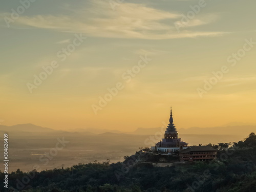 Mountain view evening of Crystal Pagoda or Chedi Kaew on top hill with yellow sun light in the sky background, sunset at Wat Tha Ton, Tha Ton District, Fang, Chiang Mai, northern of Thailand. © Yuttana Joe