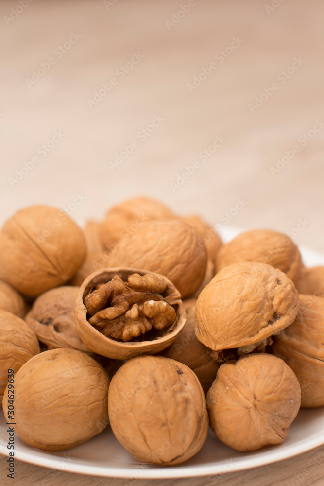walnuts on a white plate on a woodden table