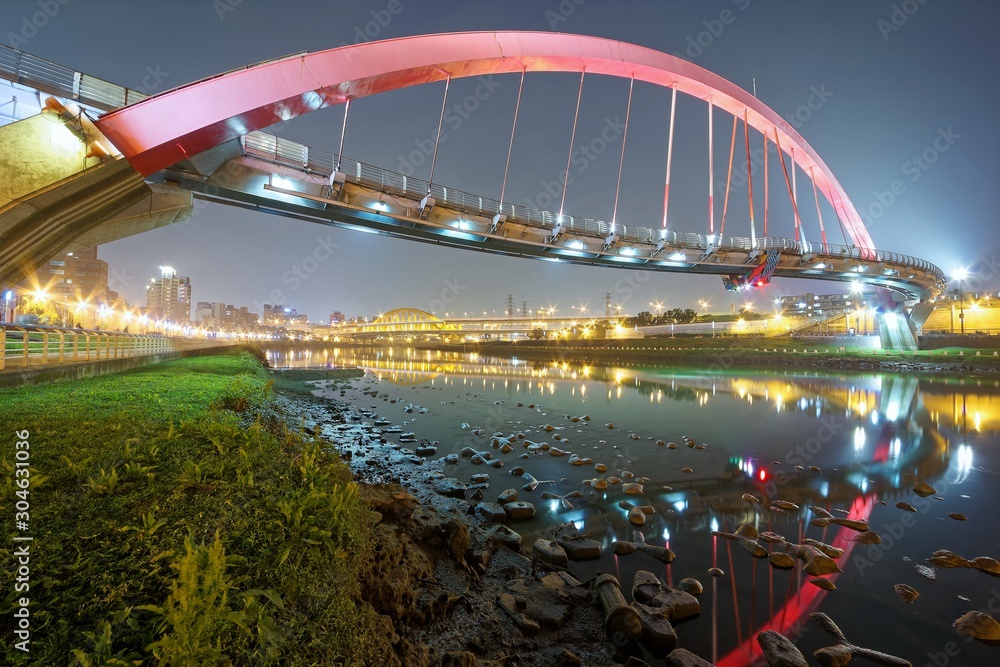 Obraz premium The famous Rainbow Bridge over Keelung River with reflections in the water at blue dusk, in Taipei, Taiwan, Asia ~A romantic landmark of Taipei, the capital city of Taiwan, under beautiful evening sky