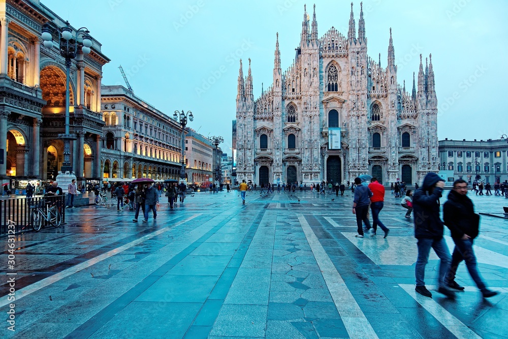 Obraz premium Majestic Milan Cathedral (Duomo di Milano) & Piazza del Duomo in evening light, Milan, Italy ~ Night view of Milan Cathedral & Vittorio Emanuele II Gallery at dusk with tourists walking in the square