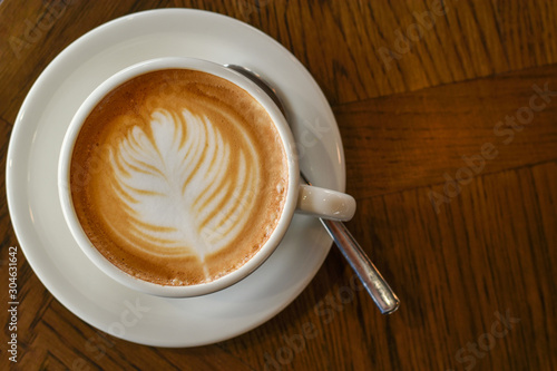 ็High angle view, Coffee latte art on wooden table.