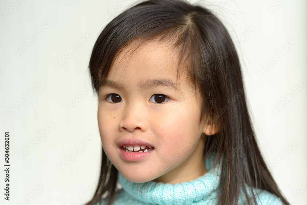 Serious pretty little Asian girl in blue sweater