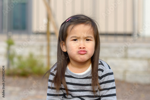 Canvas Print Cute little girl pulling a funny face at camera