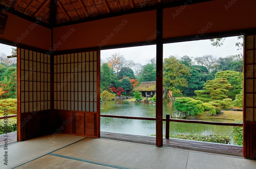 Autumn scenery of colorful foliage by the lake in a beautiful free entry Japanese garden in Kyoto Japan, with a view thru the sliding screen doors (shoji) of a tea room in a peaceful Zen ambiance Autumn scenery of colorful foliage by the lake in a beautiful free entry Japanese garden in Kyoto Japan, with a view thru the sliding screen doors (shoji) of a tea room in a peaceful Zen ambiance