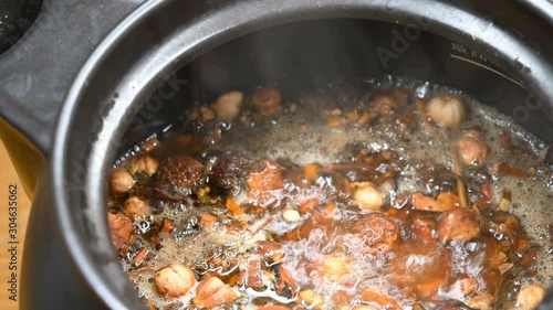 side view decocting Chinese medicinal herbs with enamel pot