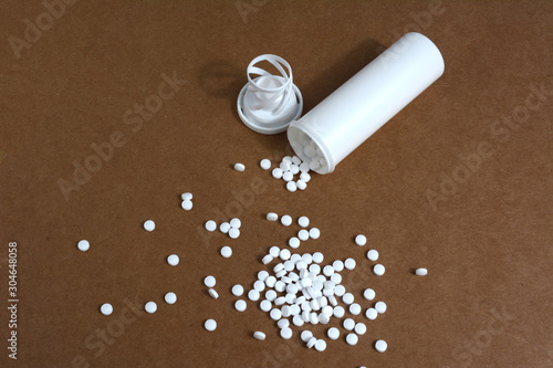 White plastic vials with pills on brown cardboard backgound