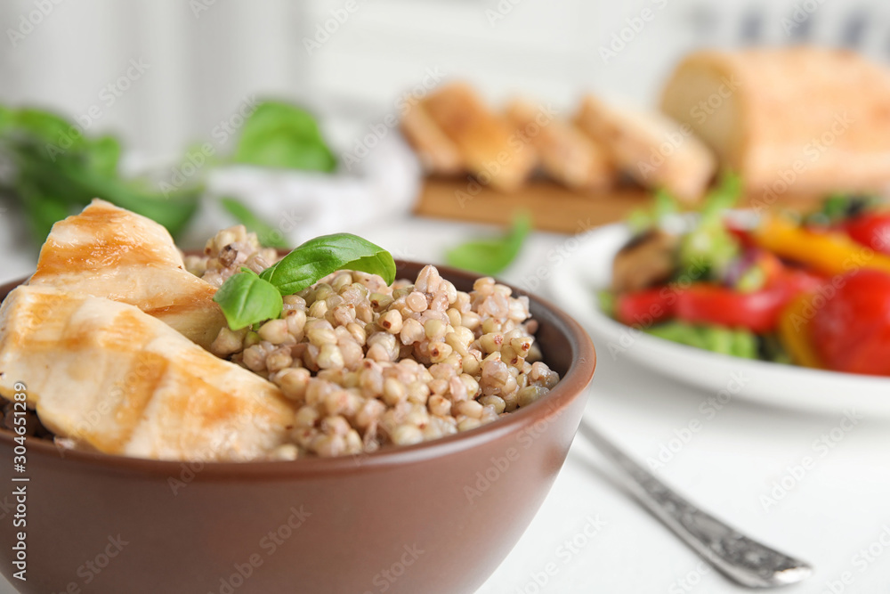 Bowl with tasty buckwheat porridge and meat, closeup Bowl with tasty buckwheat porridge and meat, closeup