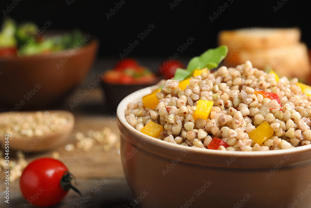 Tasty buckwheat porridge with vegetables in bowl, closeup Tasty buckwheat porridge with vegetables in bowl, closeup