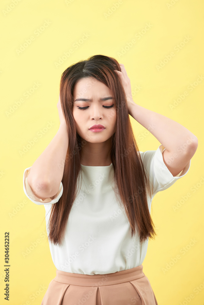Portrait of woman confused damaged dry hair on yellow background