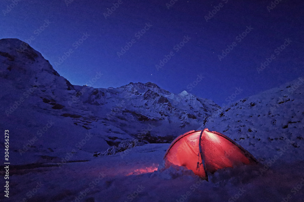 Outdoor red camping tent in Switzerland snow mountain