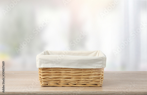 Straw empty basket with white linen on table. photo