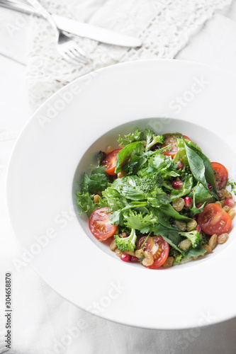 Homemade green broccoli salad with grapes, onion and tomato