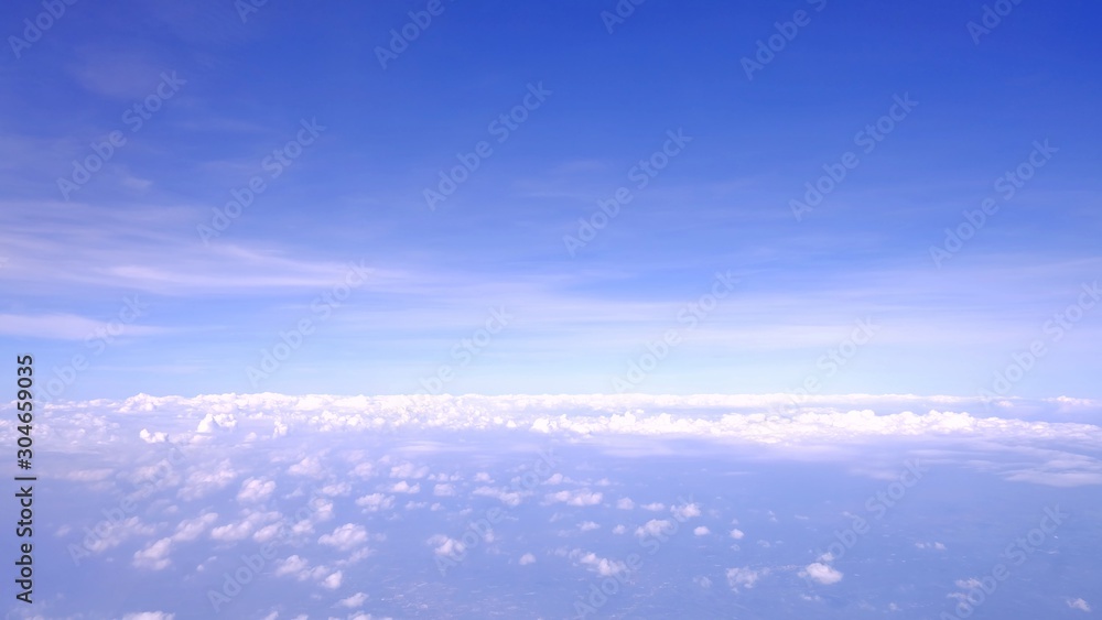 Blue sky white fluffy clouds,a view from a plane windoow