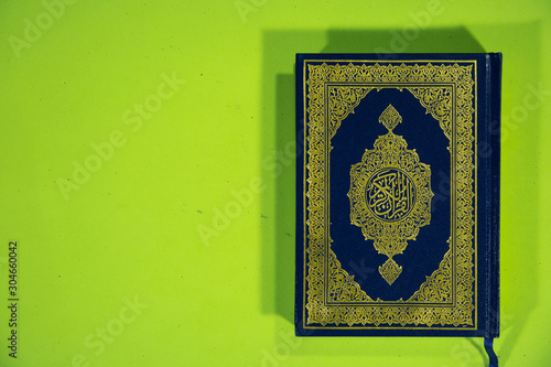 Top angle shot of Muslims Holy Book Quran Majid on green background