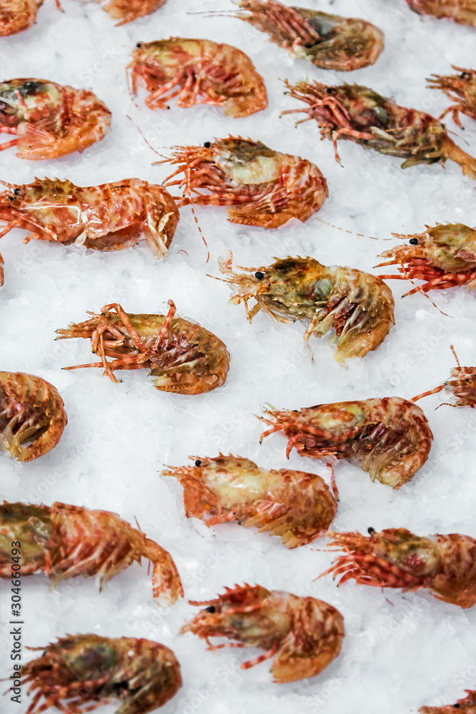 shrimp lie on the ice in the store or in the kitchen of a restaurant. Background seafood shrimp lie on the ice in the store or in the kitchen of a restaurant. Background seafood