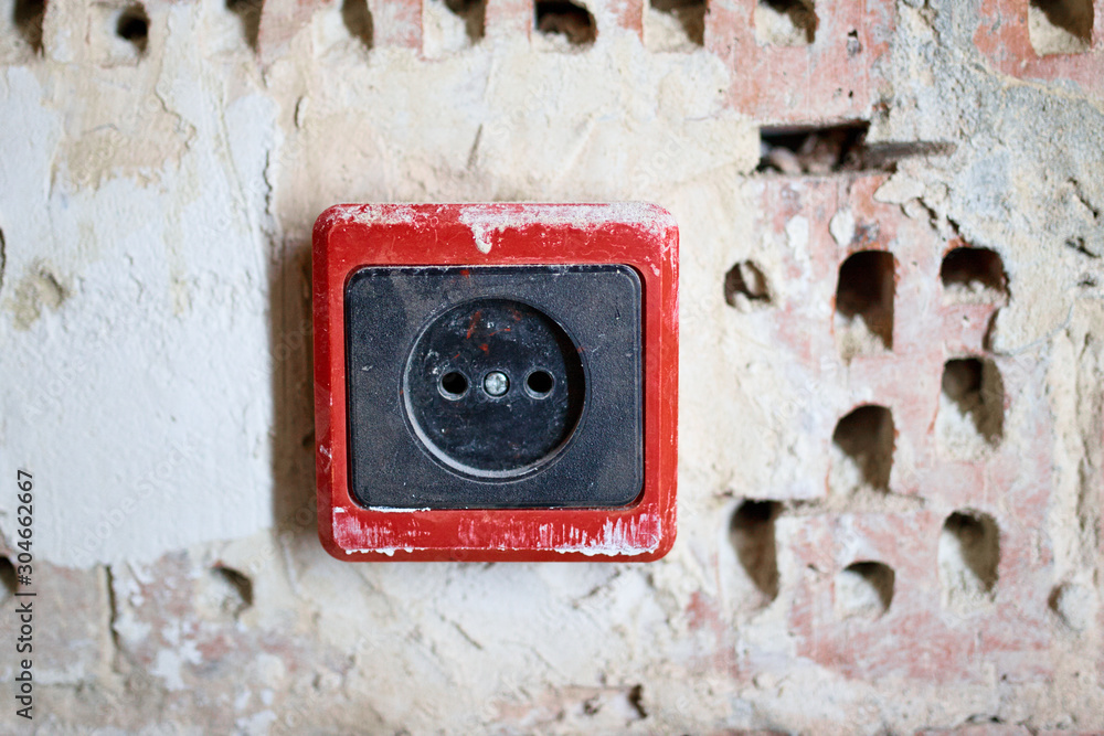 EU power outlet type C, electric point of power at home, on a red brick background with holes