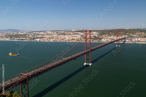 Lisbon, 25 de Abril Bridge (Ponte 25 de Abril, 25th of April Bridge) and Tagus River in Portugal viewed from above on a sunny day in the summer.