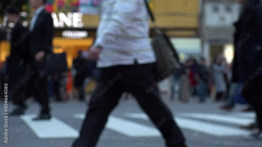 SHIBUYA, TOKYO, JAPAN - NOVEMBER 2019 : Crowd of people at Shibuya Scramble Crossing in busy early evening rush hour. Many commuters and tourists at the street. Shot in sunset time. In front focus. SHIBUYA, TOKYO, JAPAN - NOVEMBER 2019 : Crowd of people at Shibuya Scramble Crossing in busy early evening rush hour. Many commuters and tourists at the street. Shot in sunset time. In front focus.