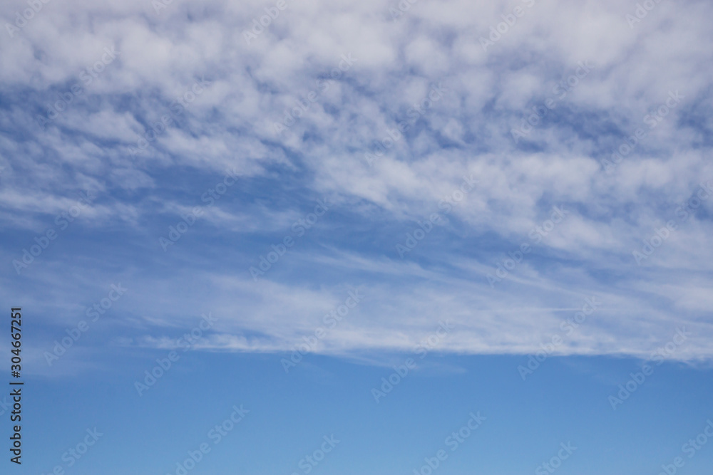 Wave of softy and white fluffy clouds under deep blue sky