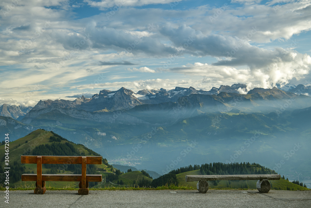 Fototapeta premium Two benches with beautiful view on Swiss Alps on top of Mount Rigi