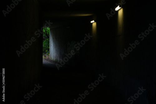 Dunkler Tunnel mit zwei Lichtern und Sicht auf Tunnelende