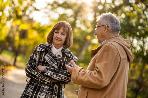 Senior couple is talking in park in autumn. © djoronimo