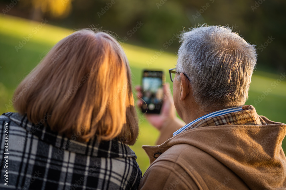 Senior couple is taking selfie in park with smartphone. Senior couple is taking selfie in park with smartphone.