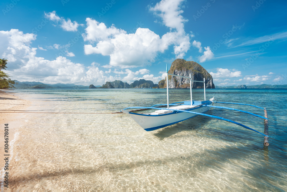 El Nido, Palawan, Philippines. traditional banca boat on sandy beach with  crystal clear water on morning island hopping trip. Amazing Pinagbuyutan  island in background. Beautiful landscape scenery Photos | Adobe Stock