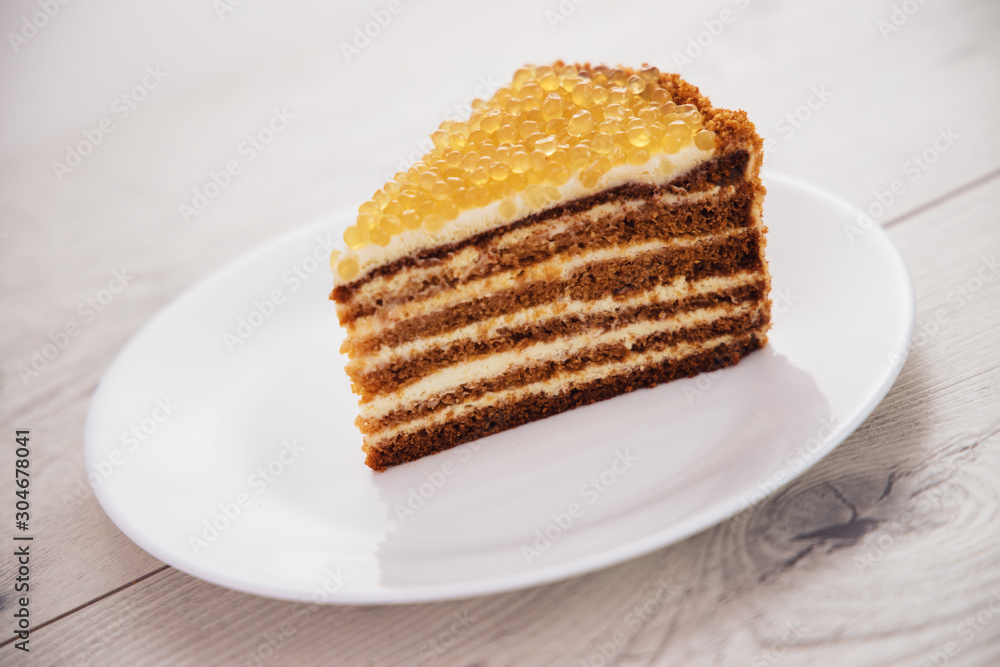 Honey cake with golden pearls isolated on white background Honey cake with golden pearls isolated on white background