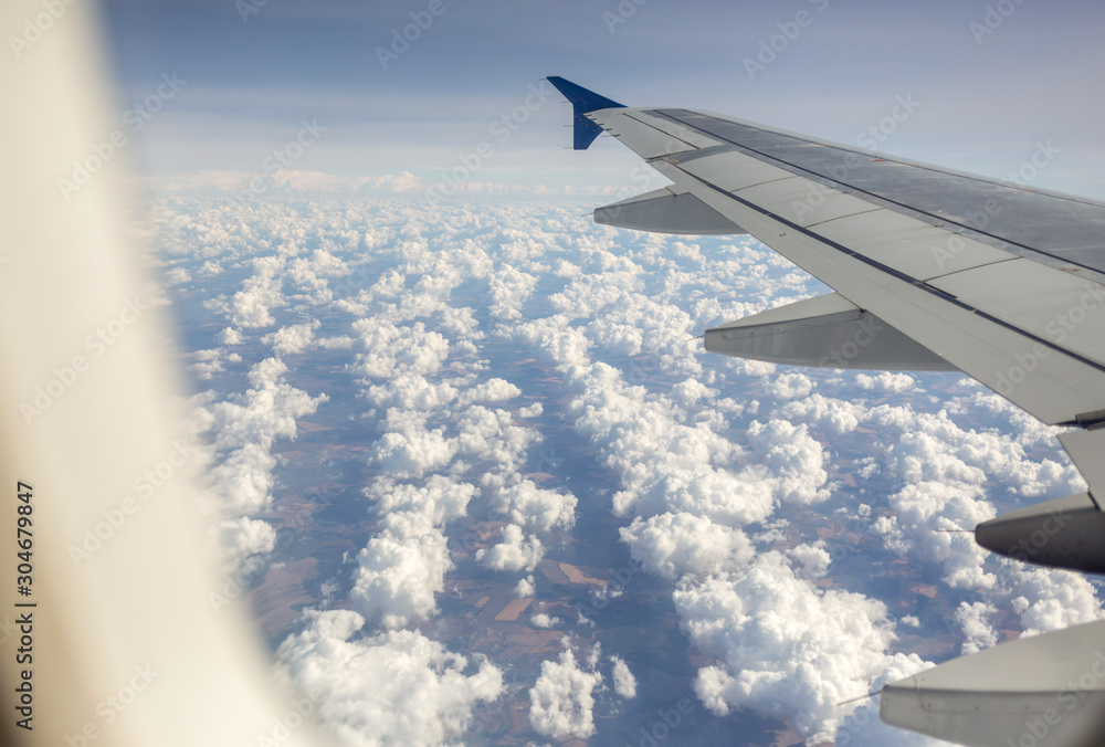 Amazing white fluffy clouds as seen from window of flying plane. Horizontal color photography. Amazing white fluffy clouds as seen from window of flying plane. Horizontal color photography.