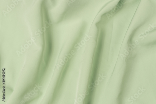 Abstract folds. Delicate silk drapery. Waving light green fabric texture background