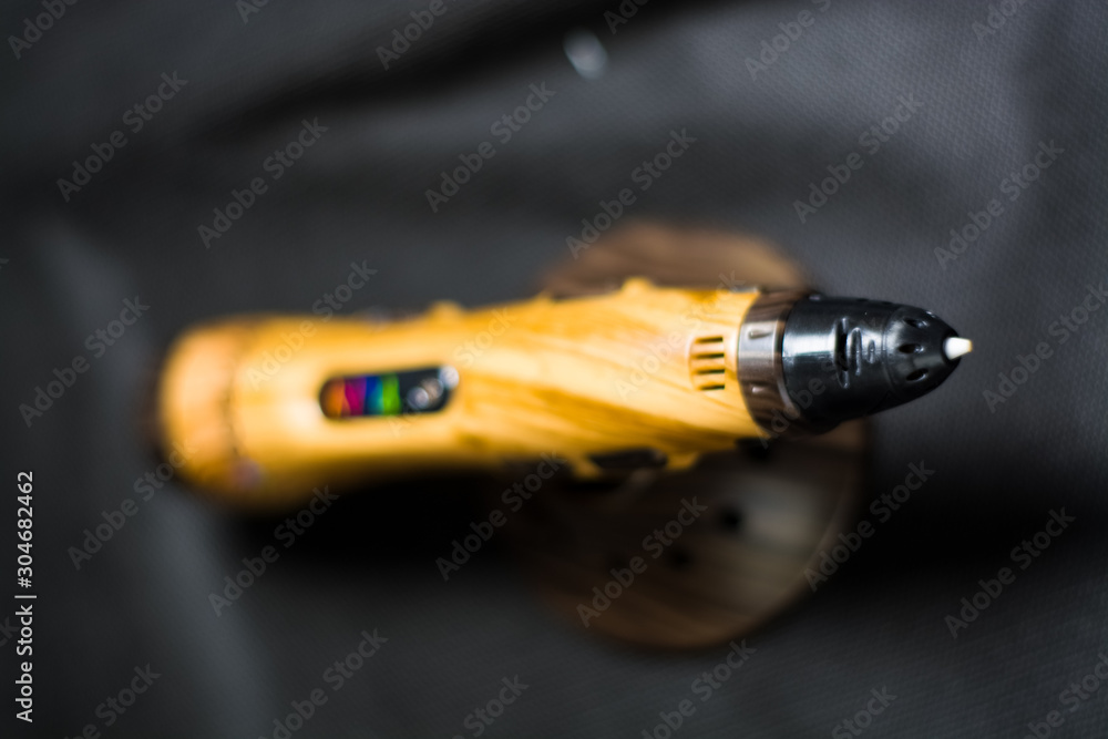 3D pen on brown stand. Tree. On black one-ton background. Hobby and creativity. 3D pen on brown stand. Tree. On black one-ton background. Hobby and creativity.