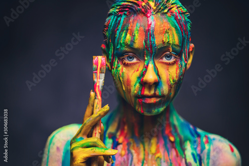 Fotografie Young woman covered with a colourful paint