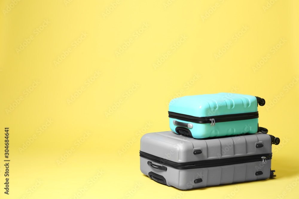 Stylish suitcases on yellow background. Space for text Stylish suitcases on yellow background. Space for text