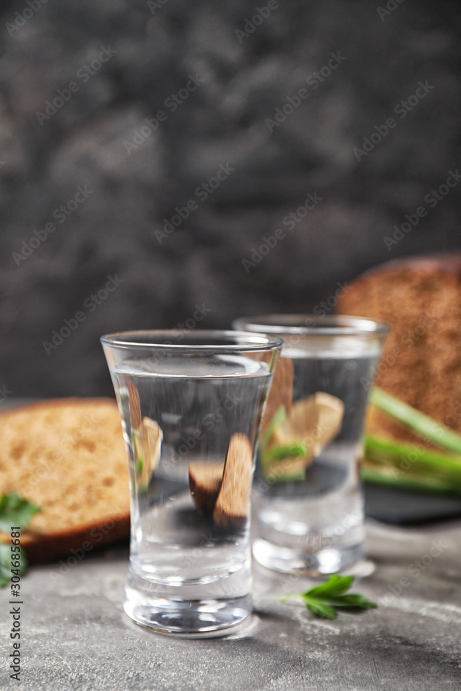 Cold Russian vodka with snacks on grey table, closeup